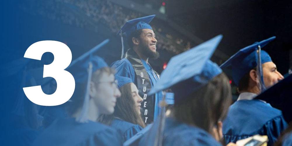 Student standing proudly during commencement - Designing Education for 21st Century